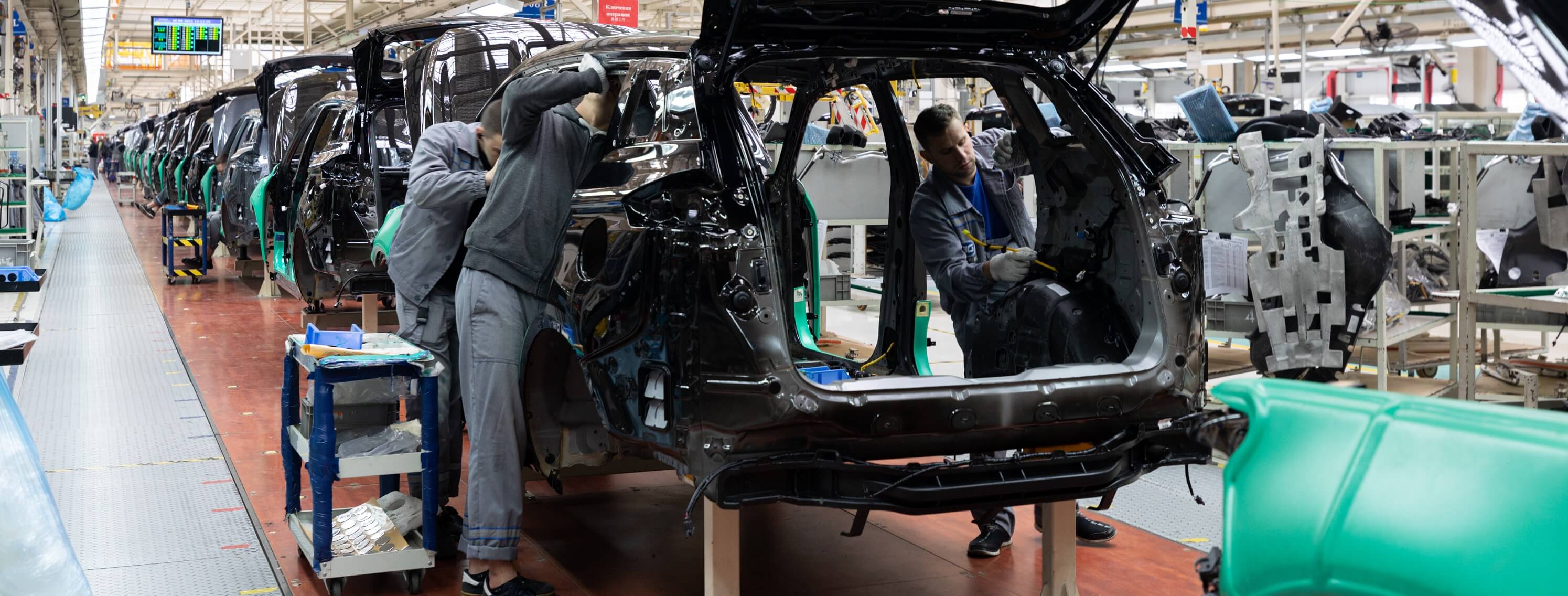Workers on the car manufacturing line assembling the parts together